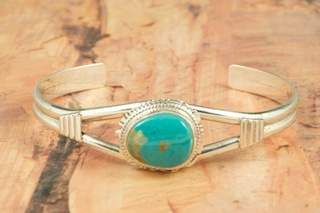 Genuine Royston Turquoise set in Sterling Silver Bracelet. The Royston Turquoise Mine was originally known as the Royal Blue Mine. It produces Turquoise that has a mixture of blues and greens in the same formation. The Royston Turquoise Mine is located in Nye County, Nevada. Created by Navajo Artist Larson Lee. Signed.
